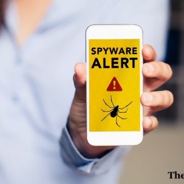 Spyware alert in a mobile phone held by hand.