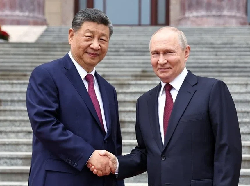 Russian President Vladimir Putin shakes hands with Chinese President Xi Jinping during a welcoming ceremony at the Great Hall of the People in Beijing, China, 20 May 2026. (Sputnik/Alexander Kazakov/Pool via Reuters)